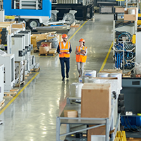 two workers walking through a manufacturing plant