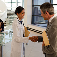 female doctor is shaking hands with a roofing contractor