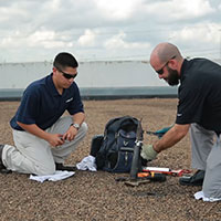 two technicians taking a roof core